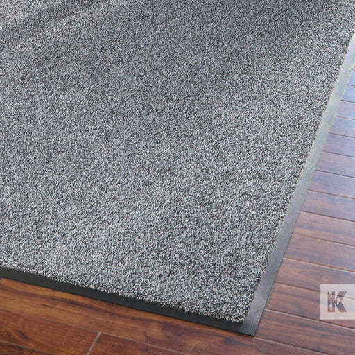 Entrance Mat - Close up of a grey mat on a wooden floor