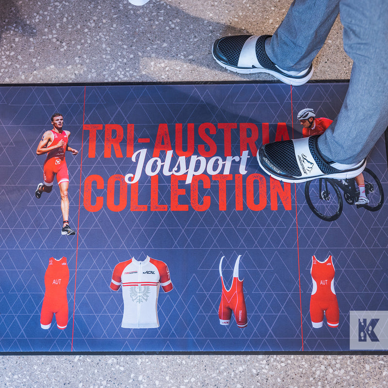 Ad-Mat - Jolsport design on an Ad-Mat, looking straight down onto the mat, with a person stood in the top right corner.