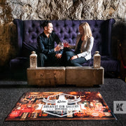 Ad-Mat - A printed mat in front of a couple sat on a purple couch drinking Gin. The mat design is branded with Stollen 1930 Gin Gallery.