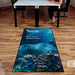 Ad-Mat - Looking down onto an office floor with a white top desk in the background. A mat in the foreground with Recon branding and an underwater scene.