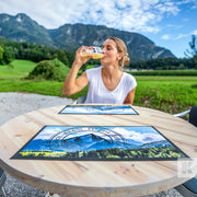 Bar-Mat - Lady enjoying a drink of beer in an outdoor nature setting with printed mats on a solid wood table top