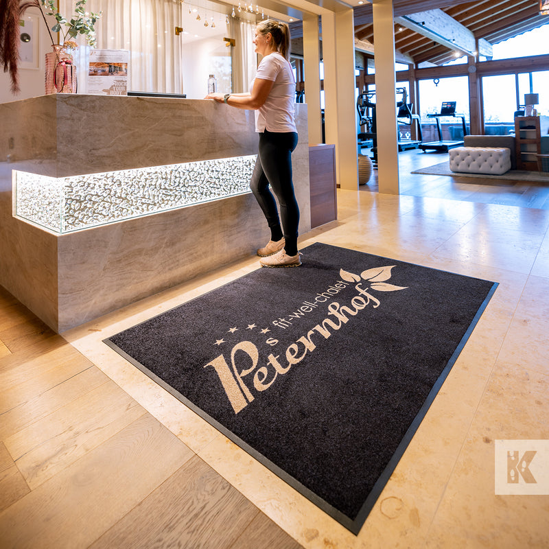 Jet-Print Mat - Reception desk with a large logo mat in front and a customer being served
