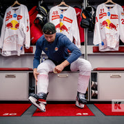 Jet-Print Light - Locker room mats that identify the position number of each Hockey team player, reflected in the team shirts hung up in the background