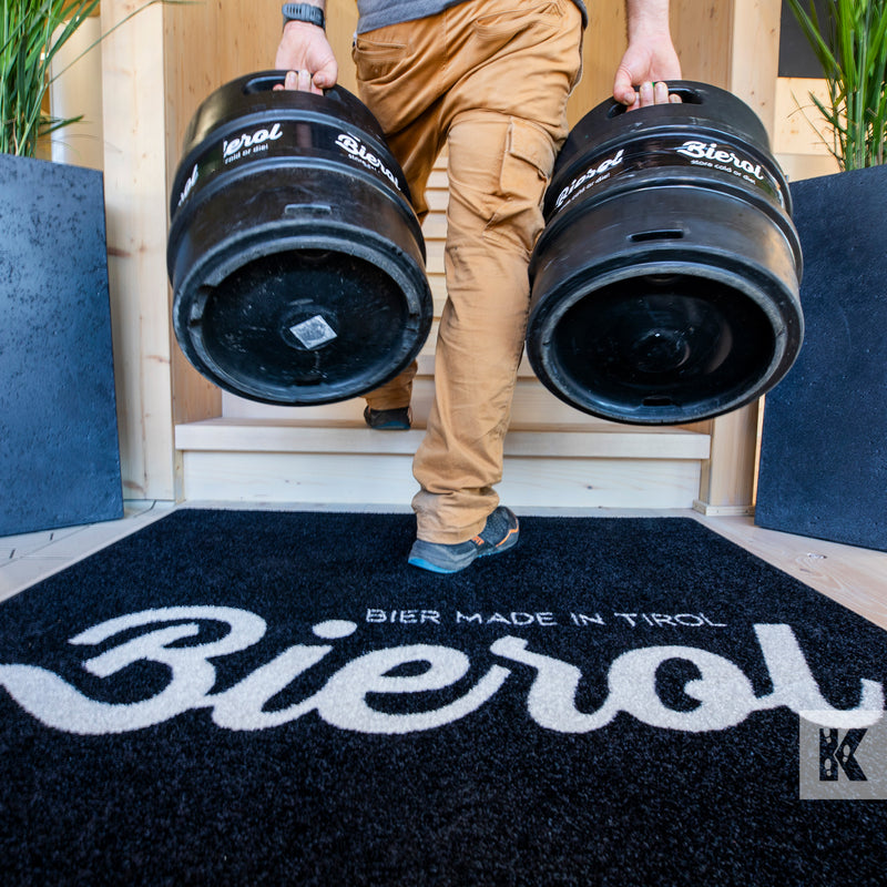 Jet-Print Light - Bierol branded mat design, a man carries two beer kegs up a flight of steps