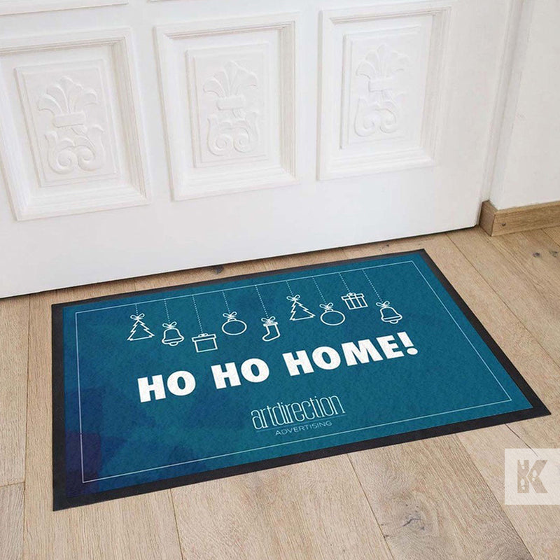 Jet-Print Velour - Ho Ho Home, example of a Christmas mat giveaway in front of a white door