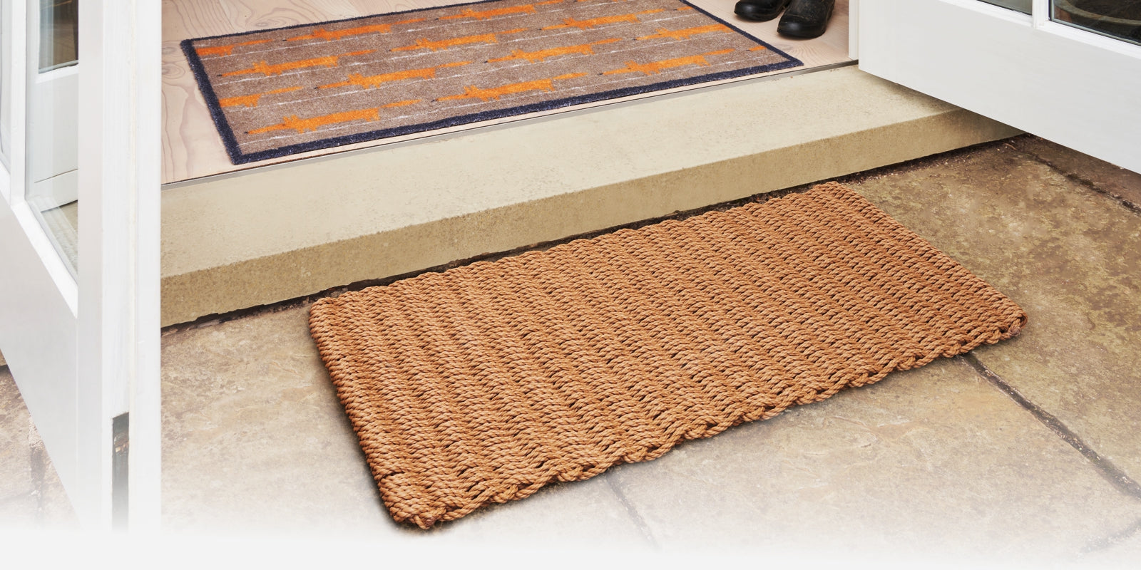 Woven rope mat in beige outside an entrance with a Mr Fox mat on the inner side
