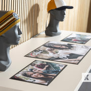 Mannequin heads wearing headwear with printed photo mats on a table.