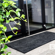 EcoAbsorb Mat - Mat in front of a glass door outside a modern office building under a shelter