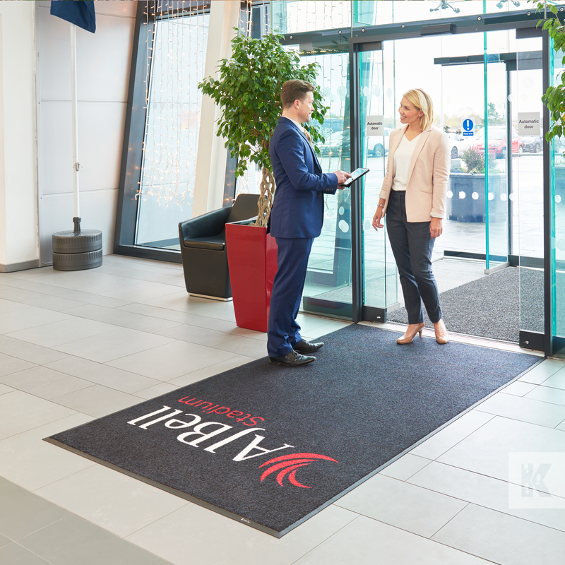 Jet-Print Mat - AJ Bell Stadium mat with couple stood chatting in a modern reception area