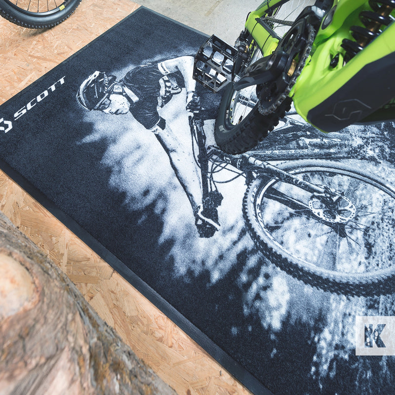 Jet-Print Velour - Scott branded bike mat, enhancing a showroom display with a green mountain bike