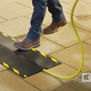 Kleen-Cable Mat EV - Close up of mans feet walking across a mat and the charging cable is hidden