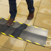 Kleen-Cable Mat EV - Top down view of a charging cable held in place by a mat, preventing a trip hazard