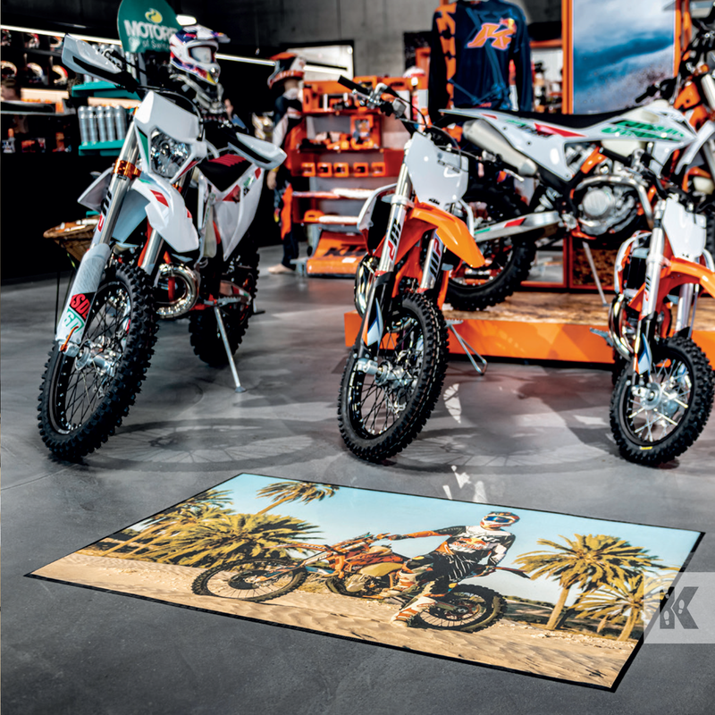 Ad-Mat - Depicting a motor bike in the desert, placed in a bike store with 4 bikes behind it.