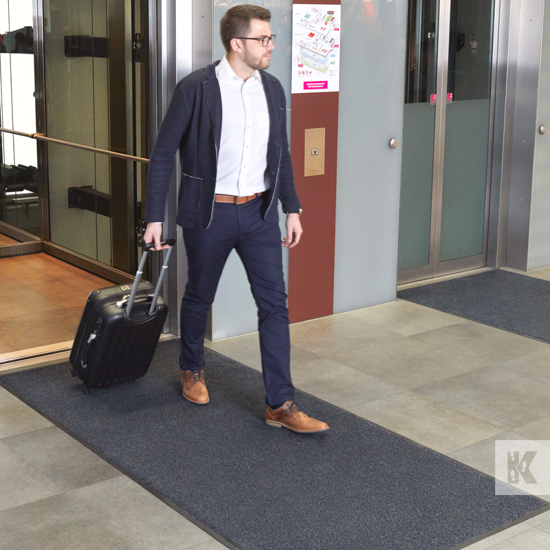 Iron-Horse - Granite - Mat exiting an elevator whilst pulling a suitcase across a mat